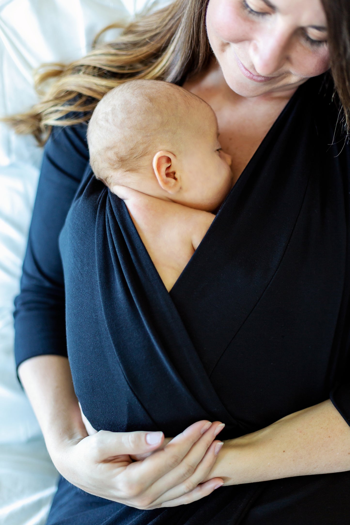 Skin-to-skin with baby in black robe. Postpartum dress. 